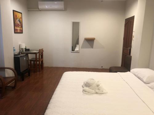 a white towel sitting on a bed in a room at avalon residence2 in Savannakhet