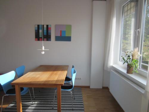a dining room with a wooden table and blue chairs at K9 Wohnungen in Münster