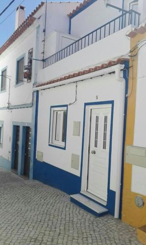 a white and blue building with a door at Casa dos Avós in Alcácer do Sal