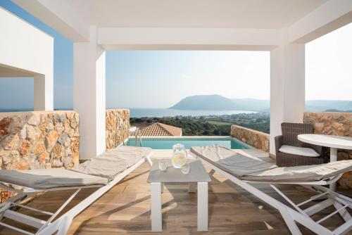 a living room with a table and chairs and a pool at White Rock of Kos Hotel - Adults only in Kefalos