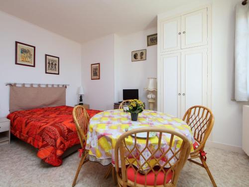 a bedroom with a table and chairs and a bed at Apartment Le Caneton-3 by Interhome in Cabourg