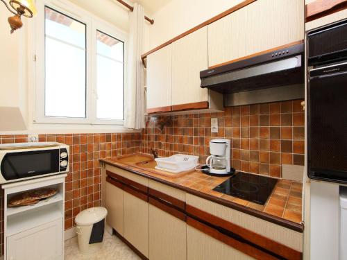 une petite cuisine avec un évier et un micro-ondes dans l'établissement Apartment Le Caneton-3 by Interhome, à Cabourg