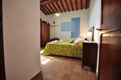ein Schlafzimmer mit einem grünen Bett mit Polka-Punkten-Bettwäsche in der Unterkunft Linearis Holiday House in Poggibonsi