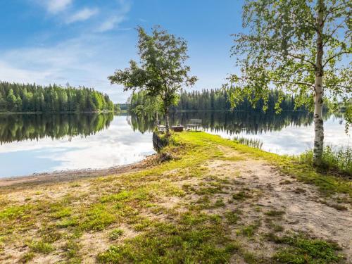 un camino de tierra junto a un lago con árboles en Holiday Home Pikkupuro by Interhome, en Tahkovuori