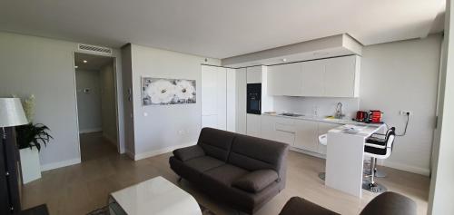 a living room with a couch and a kitchen at The Edge Apartment in Estepona