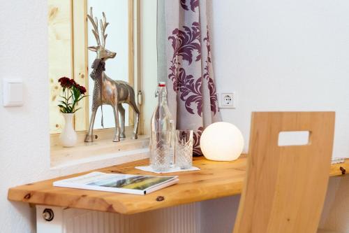 a wooden table with a mirror and a bottle on it at Alpenhotel Wanderniki in Liesing