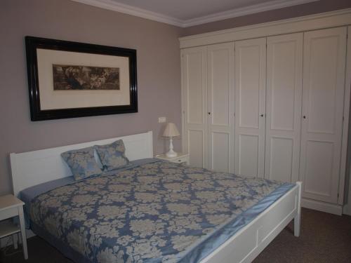 a bedroom with a bed and white cabinets at Ferienwohnung Zauberhaft in Schalkenmehren