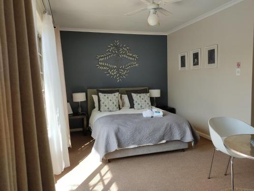 1 dormitorio con 1 cama y ventilador de techo en Palm Beach Guesthouse, en Port Elizabeth