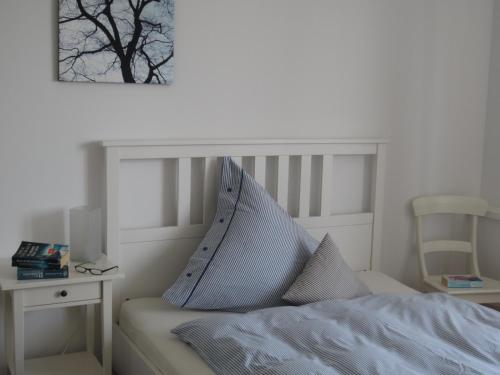a white bedroom with a bed and a table with a chair at K9 Wohnungen in Münster