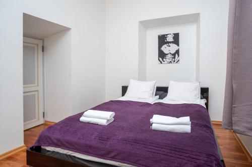 1 dormitorio con cama morada y almohadas blancas en Old Town 2-Bathroom Apartment with Sauna, en Tallin