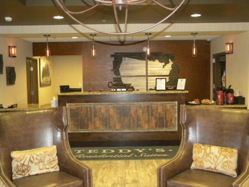 a bar with two leather chairs in a restaurant at Teddy's Residential Suites Watford City in Watford City