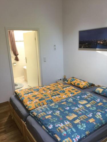 a bedroom with a bed with a quilt on it at Ruhiges Ferienhaus Wandlitz in Wandlitz