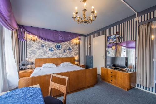 City Hotel Nieuw Minerva Leiden في لايدِن: غرفة نوم بسرير كبير وتلفزيون