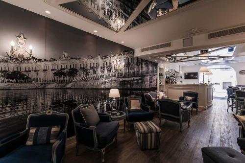 a bar with chairs and a wall with a mural at Osborne Hotel in Valletta