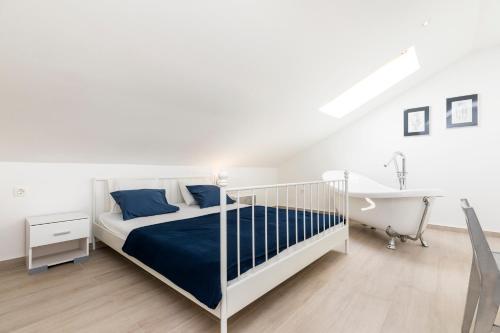 a white bedroom with a bed and a bath tub at Casa Maria 2 in Mali Lošinj