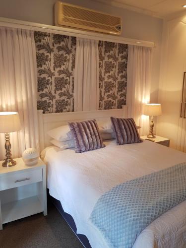 a bedroom with a large white bed with two lamps at Hunter's Lodge in Ladysmith
