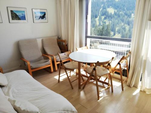 une pièce avec une table, des chaises et une fenêtre dans l'établissement Residence Cassiopee - maeva Home, à Flaine
