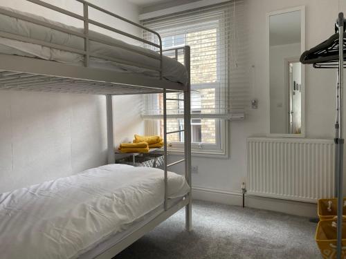 1 Schlafzimmer mit 2 Etagenbetten und einem Fenster in der Unterkunft Eastside View Apartment in Whitby
