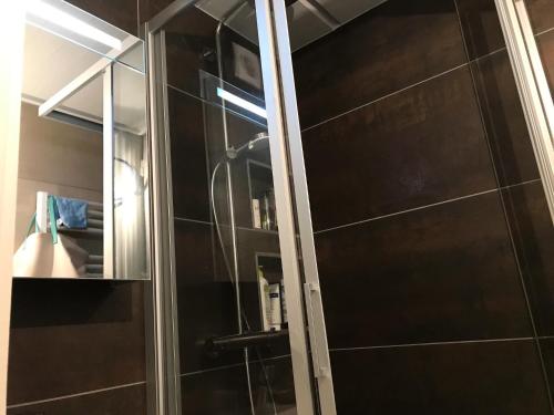 une douche avec une porte vitrée dans une salle de bain dans l'établissement Residence Cassiopee - maeva Home, à Flaine