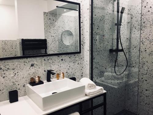 a bathroom with a sink and a shower at Hôtel 16 | 150 Montagne & Spa Nuxe in Vars