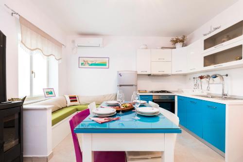 a kitchen with blue and white cabinets and a table at Casa Maria 2 in Mali Lošinj