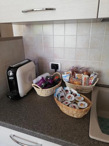 a kitchen counter with three baskets of food and a toaster at IL RIFUGIO in VALLE D'ITRIA in Locorotondo
