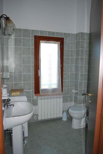 a bathroom with a sink and a toilet and a window at La Casa dei Sogni in Monteverdi Marittimo