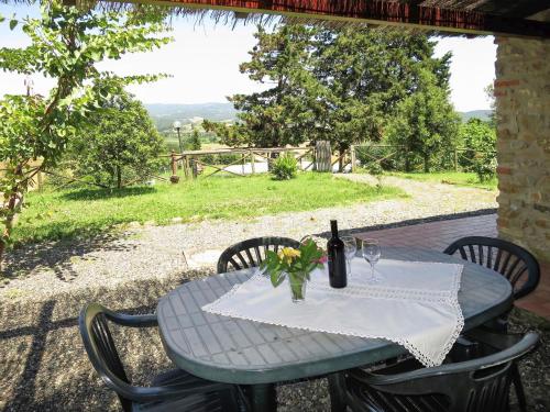 a table with a bottle of wine and flowers on it at Apartment Le Colmate-4 by Interhome in Montecatini Val di Cecina