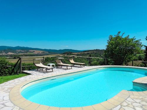 een zwembad met 2 stoelen en een tafel bij Apartment Le Colmate-1 by Interhome in Montecatini Val di Cecina