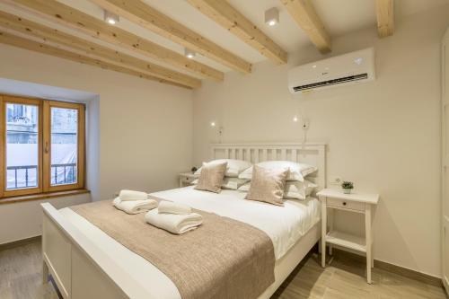 a bedroom with a bed with white sheets and a window at Cosmijeva Luxury Rooms in Split