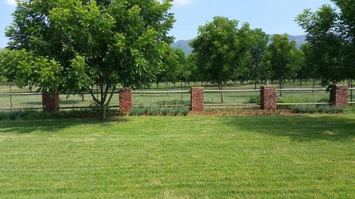 a fence in a field with trees and grass at Green Willows Guest House in Skeerpoort