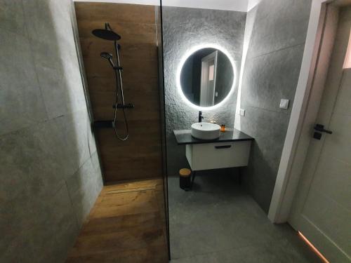 a bathroom with a sink and a shower with a mirror at Może Morze - Rezydencja Ustronie Morskie in Ustronie Morskie