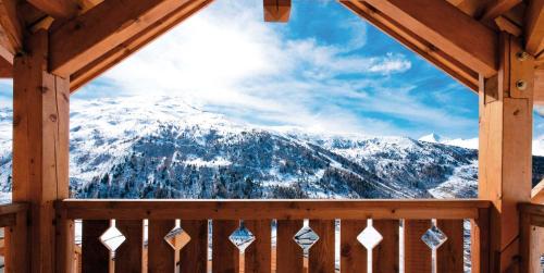 a view of a snow covered mountain from a porch at travelski home select - Chalets Le Grand Panorama II in Valmeinier