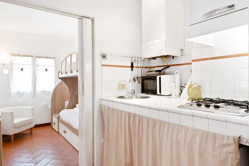 eine weiße Küche mit einer Spüle und einer Mikrowelle in der Unterkunft Palazzo Medici Apartments in Florenz