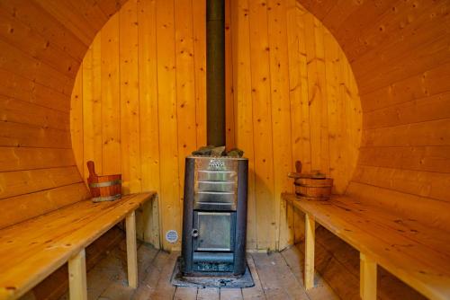 a room with two benches and an old stove at Farma Zelená Ruža in Kľačno