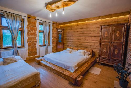 a bedroom with two beds and a wooden wall at Farma Zelená Ruža in Kľačno