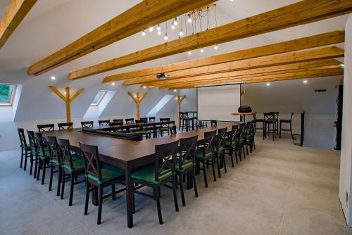 a large dining room with a long table and chairs at Farma Zelená Ruža in Kľačno