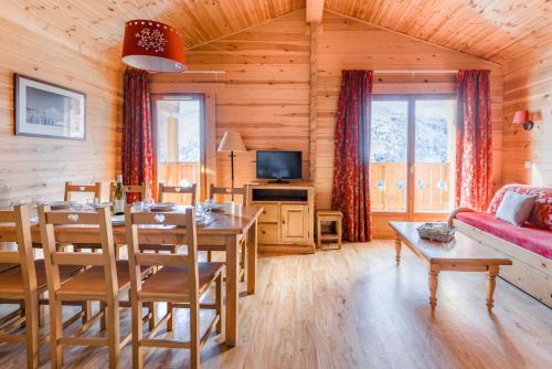a living room with a table and a dining room at travelski home select - Chalets Le Grand Panorama II in Valmeinier