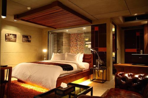 a bedroom with a large bed and a couch at The Fusion Suites in Bangkok