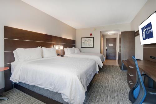 a hotel room with two beds and a flat screen tv at Holiday Inn Express Hotel & Suites Orlando - Apopka by IHG in Orlando