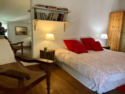 a bedroom with a bed with red pillows at Mas Du Pont De Laute in Le Cailar