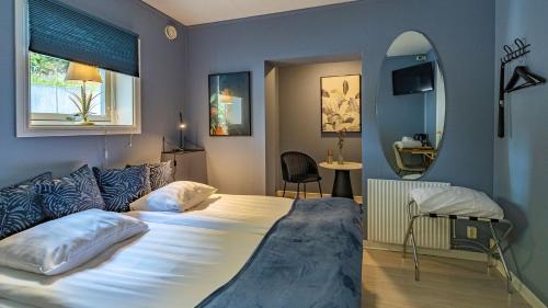 a bedroom with a large bed and a mirror at Treetop Spa Hangout & Hotel in Gothenburg