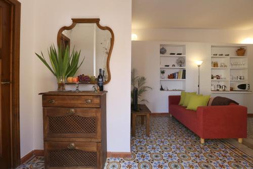 Carmen en el Albaicín con Jardin y Vistas في غرناطة: غرفة معيشة مع أريكة حمراء ومرآة
