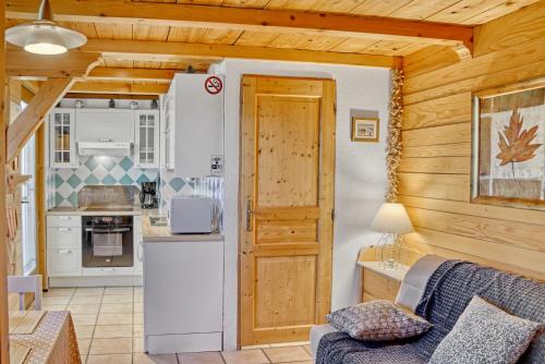 uma sala de estar com uma cozinha e um sofá numa cabina em Appartement privatif type chalet cosy et calme em Métabief