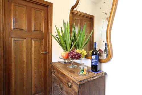un tavolo con un cesto di frutta e una bottiglia di vino di Carmen en el Albaicín con Jardin y Vistas a Granada