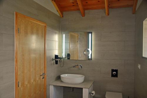 a bathroom with a sink and a mirror at Azorenhaus am Atlantik - Family House in Urzelina
