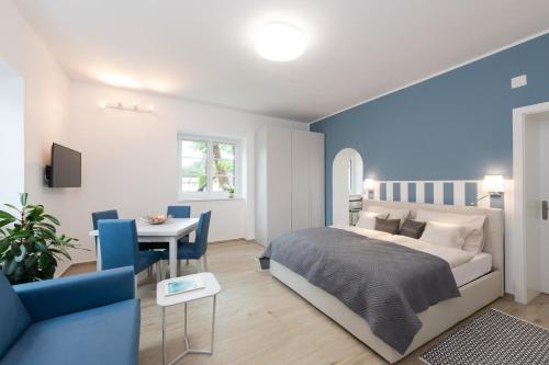 um quarto com uma cama e uma sala de jantar em Villa Bella Vista - Apartment Blue em Pörtschach am Wörthersee