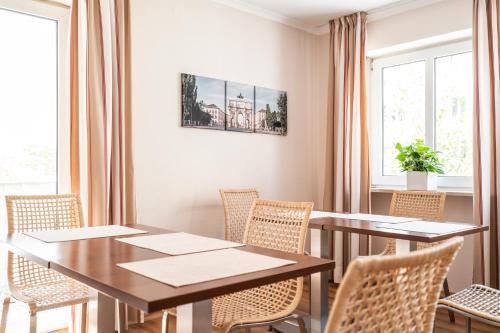 a dining room with tables and chairs and windows at Flatista Boutique Hotel - Self Check-in in Munich