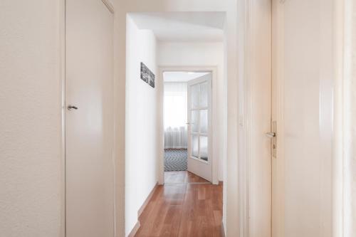 a hallway with white walls and a wooden floor at Flatista Boutique Hotel - Self Check-in in Munich