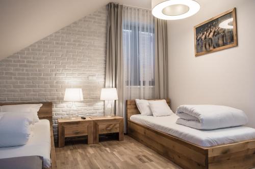 1 Schlafzimmer mit 2 Betten und Ziegelwand in der Unterkunft Hotel Naturum in Milicz
